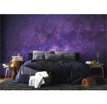 Slaapkamer met bed en fotobehang met sterrenpatroon