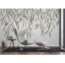 Lichte kamer met wandbehang, fauteuil en bijzettafel.