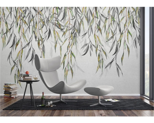 Lichte kamer met wandbehang, fauteuil en bijzettafel.