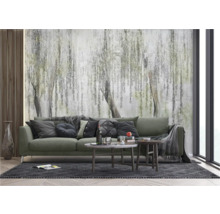 Woonkamer met groene bank en fotobehang met boommotief