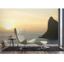 Woonkamer met fauteuil, voetenbank en fotobehang met zeethema