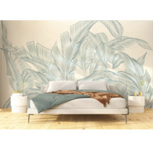 Slaapkamer met bed voor een behang met een botanisch bladerdesign