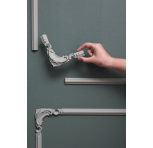 Wandpanelen met decoratieve elementen en hand op grijze muur