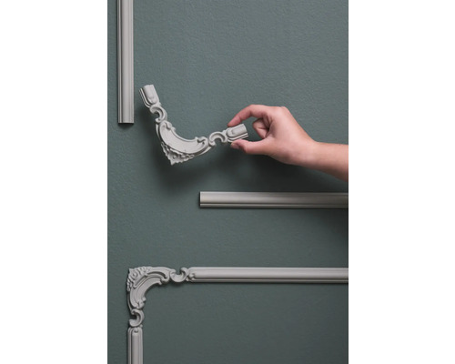 Wandpanelen met decoratieve elementen en hand op grijze muur