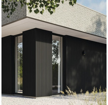 Close-up van een modern huis met een gevel van lambrisering en bakstenen.