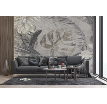 Woonkamer met bank, salontafel en een behang met plantenmotieven.