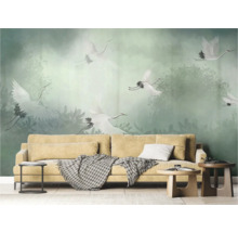 Woonkamer met beige bank en behang met kraanvogelmotieven