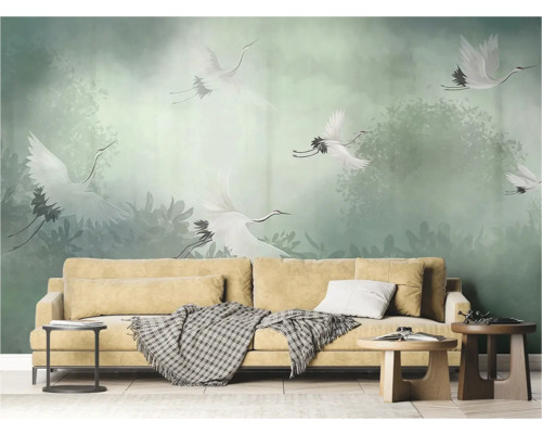 Woonkamer met beige bank en behang met kraanvogelmotieven