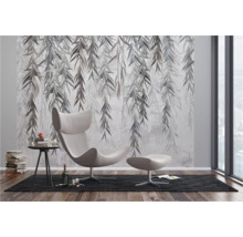 Decoratieve wand met een bladerenmotief achter een fauteuil en een bijzettafel