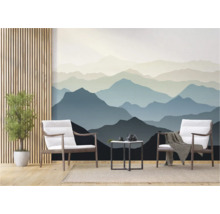 Woonkamer met behang van een berglandschap, twee stoelen en een kleine tafel.