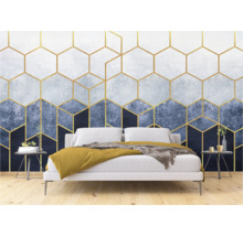 Een slaapkamer met een behang met gouden geometrische vormen achter een bed