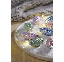 Decoratieve dennenappels met lichtketting op een bord met kunstsneeuw