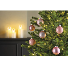 Close-up van een versierde kerstboom met roze kerstballen en kerstverlichting.
