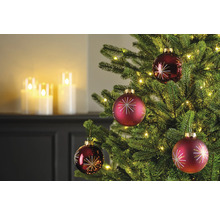 Close-up van een kerstboom met rode kerstballen en lichtjes