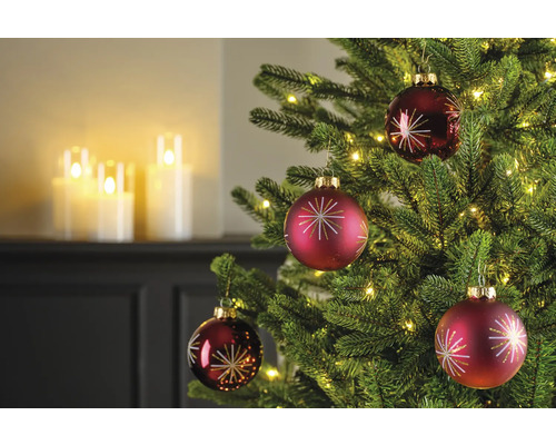 Close-up van een kerstboom met rode kerstballen en lichtjes