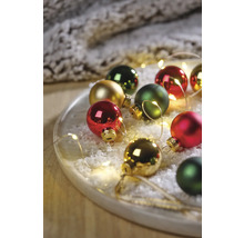 Decoratieve kerstballen op een bord met kunstsneeuw en lichtjes