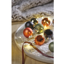 Decoratieve kerstballen met lichtsnoer op een bord
