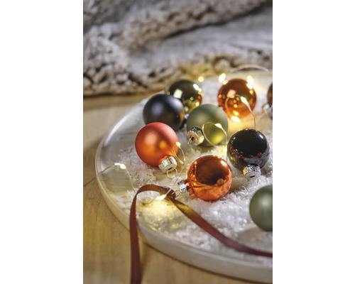 Decoratieve kerstballen met lichtsnoer op een bord