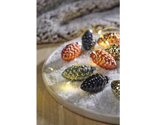 Decoratieve dennenappels met lichtsnoer op een bord