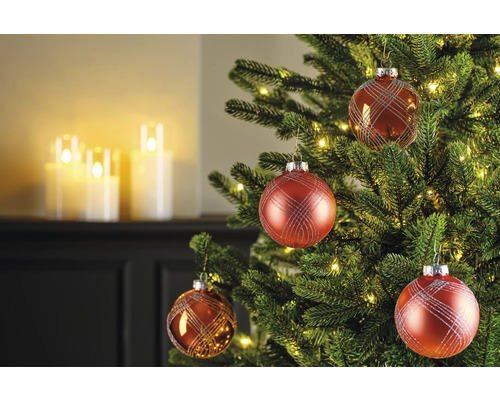 Versierde kerstboom met rode kerstballen en warm witte lichtjes
