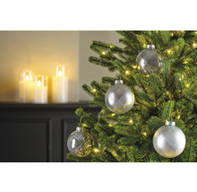 Versierde kerstboom met zilveren kerstballen en lichtjes.