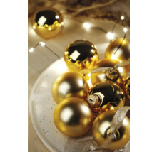 Decoratieve gouden kerstballen op een schaal met lichtsnoer