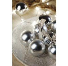 Decoratieve kerstballen met glanzend oppervlak en linten op een bord