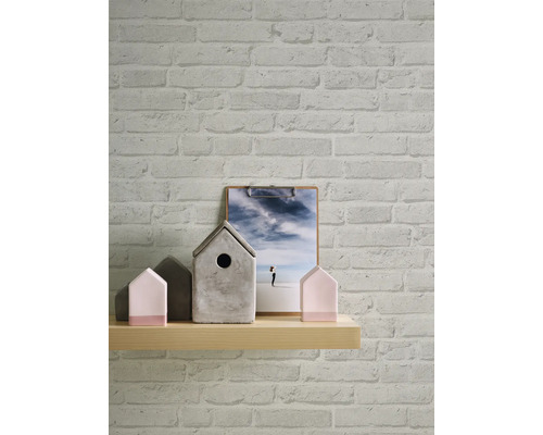 Muur met bakstenen behang, houten plank met huisdecoraties en foto op een klembord