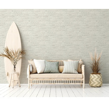 Lichte ruimte met bakstenen muur, bank, surfplank en decoratieve planten