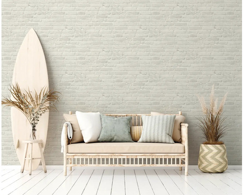 Lichte ruimte met bakstenen muur, bank, surfplank en decoratieve planten
