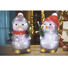 Twee pinguïnfiguren met verlichting en kerstbomen als decoratie