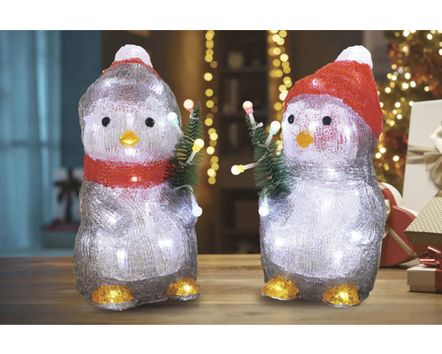 Twee pinguïnfiguren met verlichting en kerstbomen als decoratie