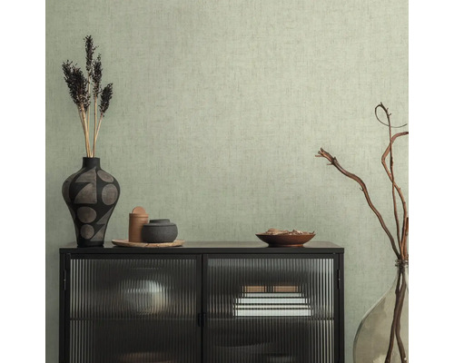Interieurscène met een zwart dressoir met glazen voorkant voor een gestructureerd behang