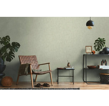 Lichte kamer met patroonbehang, rieten stoel en decoraties