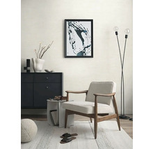 Woonkamer met fauteuil, dressoir, staande lamp en decoratie