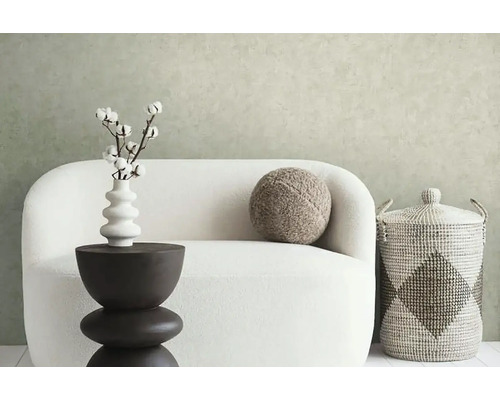 Decoratieve woonsfeer met bank, bijzettafel, vaas met katoenen takken, kussen en opbergmand