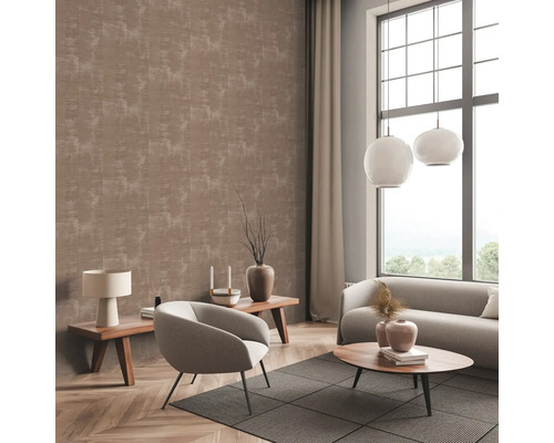 Woonkamer met patroonbehang, bank, fauteuil en bijzettafels.