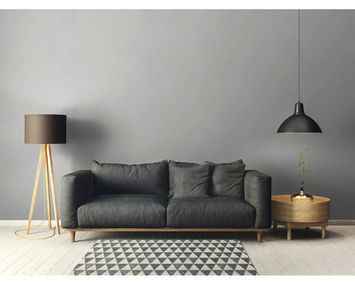 Woonkamer met bank, vloerlamp, hanglamp en bijzettafel op een geometrisch tapijt