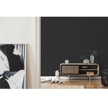 Woonkamer met dressoir, decoratie, vloerkleed en hond op de vloer