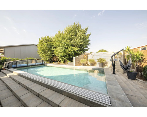 Buitenzwembad met afdekking, trap en hangmatframe in de tuin