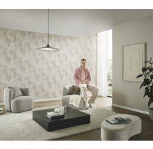 Moderne woonkamer met patroonbehang, twee fauteuils, een salontafel en een persoon