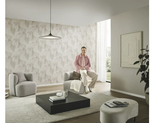 Moderne woonkamer met patroonbehang, twee fauteuils, een salontafel en een persoon