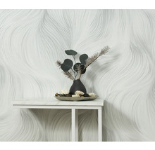 Scène met een wit behang met golvend patroon en een tafeldecoratie met een vaas