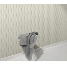 Scène met driedimensionaal wanddesign, witte kruk en grijze handdoek