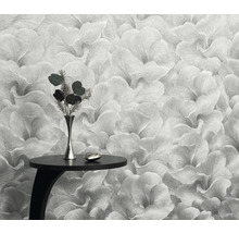 Close-up van een bloemenbehang met een klein tafeltje en een vaas