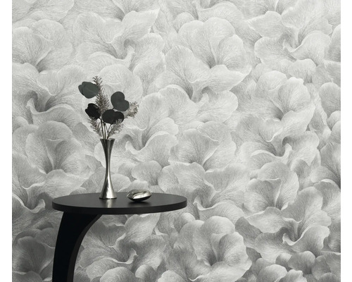 Close-up van een bloemenbehang met een klein tafeltje en een vaas