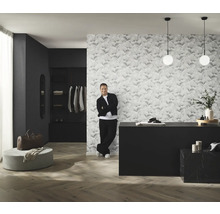 Kameroverzicht met behang met patroon, commode, verlichting en man