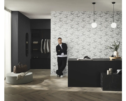 Kameroverzicht met behang met patroon, commode, verlichting en man