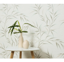 Decoratief behang met bladerpatroon, gecombineerd met een tafel en kamerplanten in vazen.