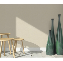 Scene met drie houten krukken en drie slanke decoratieve vazen op een houten vloer voor een muur